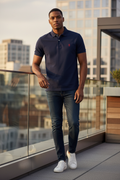 Model wearing navy premium cotton polo shirt with red crowned shield logo