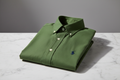 LANZO'S COLLECTION Oxford Button-Down Shirt in Olive Green, folded on marble surface